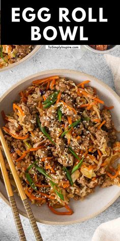 an egg roll bowl with carrots, green onions and sesame seeds in it next to chopsticks