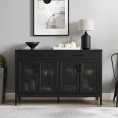 a black sideboard in a living room next to a chair