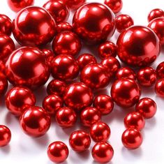 red pearls are scattered on a white surface