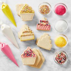 several decorated cookies are sitting on a table with sprinkles and icing