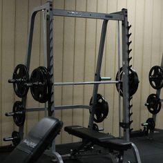 an empty gym room with barbells and weight machines