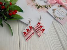 red and white cross stitched heart shaped earrings