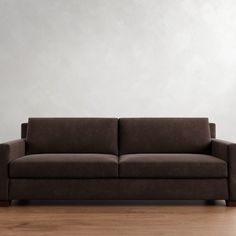 a brown couch sitting on top of a hard wood floor