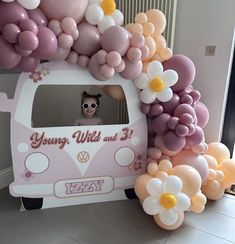 a vw bus decorated with balloons in the shape of flowers and daisies for a birthday party