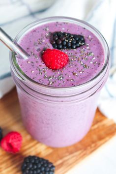 a smoothie with berries and chia seeds in a glass on a cutting board