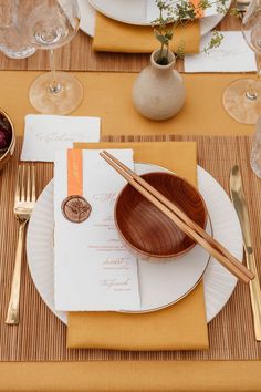 Place setting with yellow table rubber, bamboo place mat, gold cutlery, brown rice bowls and wooden chopsticks for Japanese wedding Chopstick Table Setting, Japanese Dinner Table Setting, Japan Table Setting, Japanese Table Setting Ideas, Asian Inspired Table Settings, Asian Dinner Table Setting, Vietnamese Table Setting, Japanese Place Setting