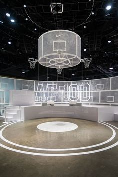 an empty basketball court with the word hoop shot projected on it's wall and lights hanging from the ceiling