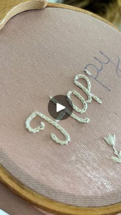 a close up of a cross stitch on a piece of fabric with the word god written in cursive writing