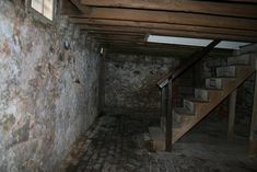 an empty room with brick floors and stairs