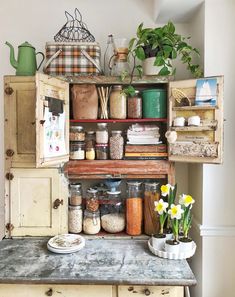 an old cabinet is filled with spices, herbs and other kitchen items on top of it