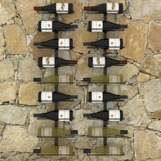 several bottles of wine are lined up against a stone wall and placed on top of each other