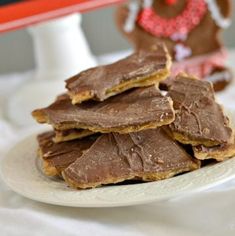 a white plate topped with chocolate covered pretzels next to a gingerbread man