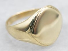 This plain signet ring is crafted from green gold for a timeless touch. Its simple, classic design is easy to wear and pairs well with any style. Enjoy timeless elegance with this beautiful piece of jewelry.Market Square Jewelers works with one of the finest hand engravers in the northeast. With over 30 years of experience, our engraver hand carves lettering, monograms, crests, or patterns in period-specific styles. Choose from our many monogram options shown in the listing or contact us directly with your own crest, or monogram, or for additional information, and pricing!Metal: 14K Green GoldTop Measurements: 13.5 mm, Square Ring Size: 8.50 Marks: "M-14" Stamped on the inside band Jewelry Market, Plain Gold Ring, Market Square, Personalized Ring, Pocket Watch Chain, Square Rings, Gold Top, Watch Chain, Unisex Ring