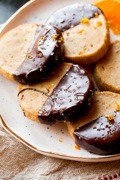 chocolate covered donuts on a plate with an orange