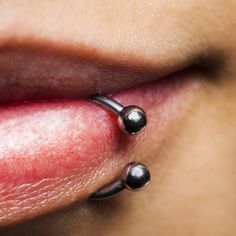 a close up of a person's nose with piercings on it