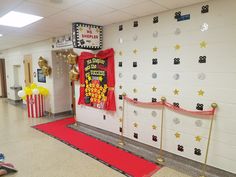 a school hallway decorated with red carpet and gold stars on the wall, along with decorations