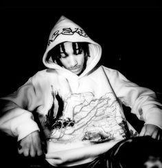 a young man wearing a hoodie sitting down