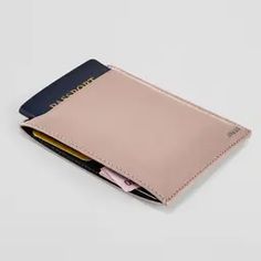 a pink wallet with two cards in it on a white surface and one has a blue card slot