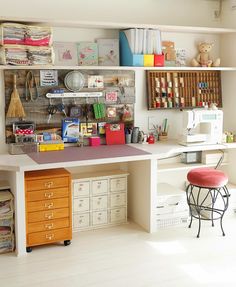 a sewing room with lots of crafting supplies on the desk and shelves above it