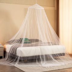 a bed with a white mosquito net over it