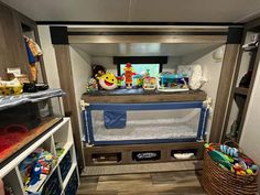 the inside of an rv with toys and other items on it's shelfs