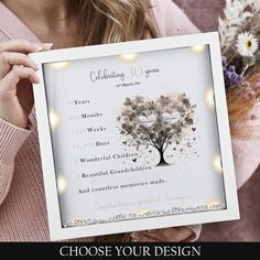 a woman holding up a framed poster with the words, choose your design on it