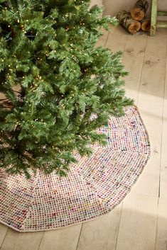 a small christmas tree in the corner of a room with a rug on the floor