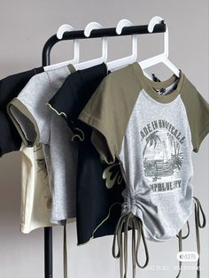 three shirts are hanging on a clothes rack