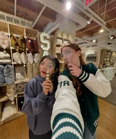 two women looking through magnifying glass in a store