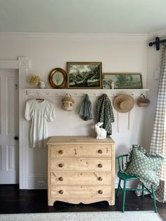 a room with a dresser and pictures on the wall