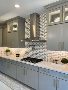 a kitchen with gray cabinets and white counter tops