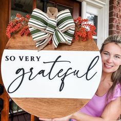 a woman holding up a sign that says so very grateful with bows on it's head