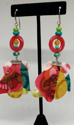 Fun and festive earrings made with multi-colored/textured fabric and an assortment of bright colored beads, approximately 3 1/2" inches in length. Ear hooks are surgical steel. Multicolor Vibrant Jewelry With Ear Wire, Colorful Vibrant Earrings With Ear Wire, Unique Multicolor Large Beads Earrings, Unique Multicolor Beaded Earrings For Party, Vibrant Multicolor Jewelry With Ear Wire, Unique Multicolor Earrings With Large Beads, Vibrant Multicolor Earrings, Multicolor Beaded Earrings For Beach, Multicolor Beach Earrings With Ear Wire