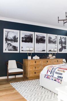 a bedroom with pictures on the wall and a bed in front of two dressers