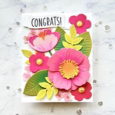 a close up of a greeting card with flowers on it and congratulations written on the front