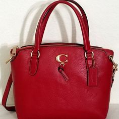 This Beautiful And Rare Coach Remi Satchel Bag Comes In True Red Color. It's Made From Rich Top Quality Soft Polished Pebbled Leather And Features Zippered Top Closure, Gold Tone Signature Hardware, C Logo Details, And A Signature Hand Tag. Superior Quality Craftsmanship With A Sleek Silhouette, Attractive Stitching And Many Other Details Gives This Bag A Unique And Classy Look. This Satchel Bag Features Front And Back Pockets With A Magnetic Closure, And Large Main Compartment With A Fully Line Red Textured Leather Tote Bag, Chic Red Satchel With Textured Leather, Red Pebbled Leather Bag For Everyday Use, Red Textured Leather Top Handle Shoulder Bag, Chic Red Textured Leather Satchel, Red Textured Leather Satchel With Top Handle, Red Top Handle Satchel With Textured Leather, Red Textured Leather Top Handle Satchel, Coach Crossbody Bag In Textured Leather