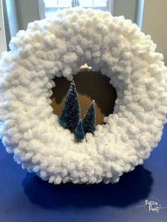 a white wreath with blue trees on it