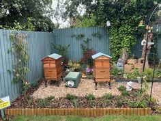 several beehives in a garden with gravel and grass