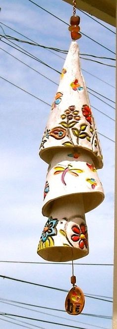 a decorative item hanging from the side of a building with wires in the back ground