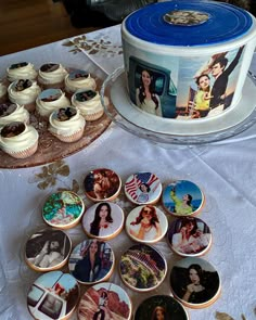 a table topped with cupcakes next to a cake covered in pictures on plates