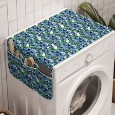 a white washer sitting in front of a dryer next to a tiled wall