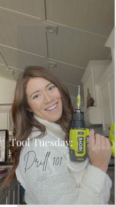 a woman in a white sweater holding a yellow and black driller with the words tool tuesday written on it