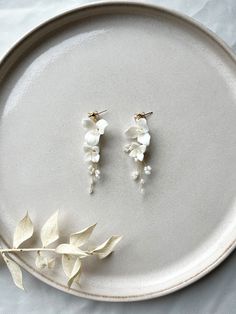 Are you looking for floral bridal earrings? You'll find them here! These earrings made of white ceramic flowers are a real eye-catcher and perfect as bridal jewelry! Stud earrings made of 316L stainless steel jewelry wire Pearls and fine ceramic flowers For more jewelry inspo, check out our shop! You can also find matching hairpins here 🤍 Photos: dark-haired model: Diana Alyasin Blonde model: Janine Klebolte 💫 Delicate White Jewelry With 3d Flowers, Delicate White Flower Shaped Bridal Earrings, Delicate White Flower-shaped Bridal Earrings, White Wedding Jewelry With Flower Decoration, White Flower Decoration Wedding Jewelry, White Pearl Drop Earrings For Bride, Bride White Pearl Drop Earrings, White Drop Earrings For Bride, White Flower-shaped Pearl Earrings For Anniversary