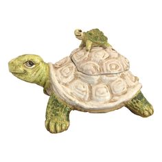 a ceramic turtle figurine sitting on top of it's shell