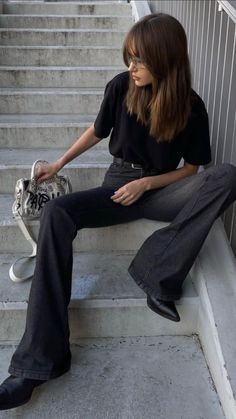 a woman sitting on the steps with her skateboard