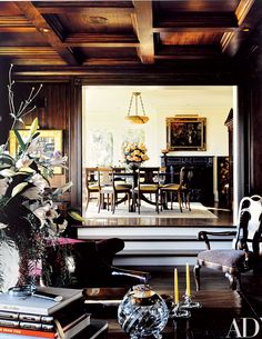 the dining room is decorated with antique furniture and flowers in vases on the table