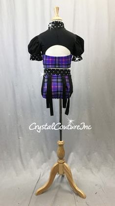 A Black and Purple Plaid lycra two-piece with a half-sleeved crop top and trunks. The cropped top has cut outs near the upper chest and mid-back, and rhinestoned collar and sleeves with a zipper down the back. The trunks are mostly Purple plaid with Black sides and a rhinestoned waist band, and are detailed with hanging suspender-like straps off of silver hoops on each hip. Over 1 gross of stunning Swarovski XIRIUS Crystal 30ss rhinestones!!! Fitted Purple Sets With Short Sleeves, Baggy Clothing, Costumes For Sale, Purple Plaid, Silver Hoops, Half Sleeves, Two Piece, Plaid, Crop Tops