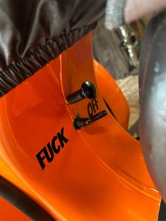 an orange motorbike with black lettering on the front and back fenders is shown