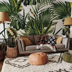 a living room with palm leaves on the wall and rugs in front of it