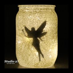 a glass jar with a shadow of a fairy on it